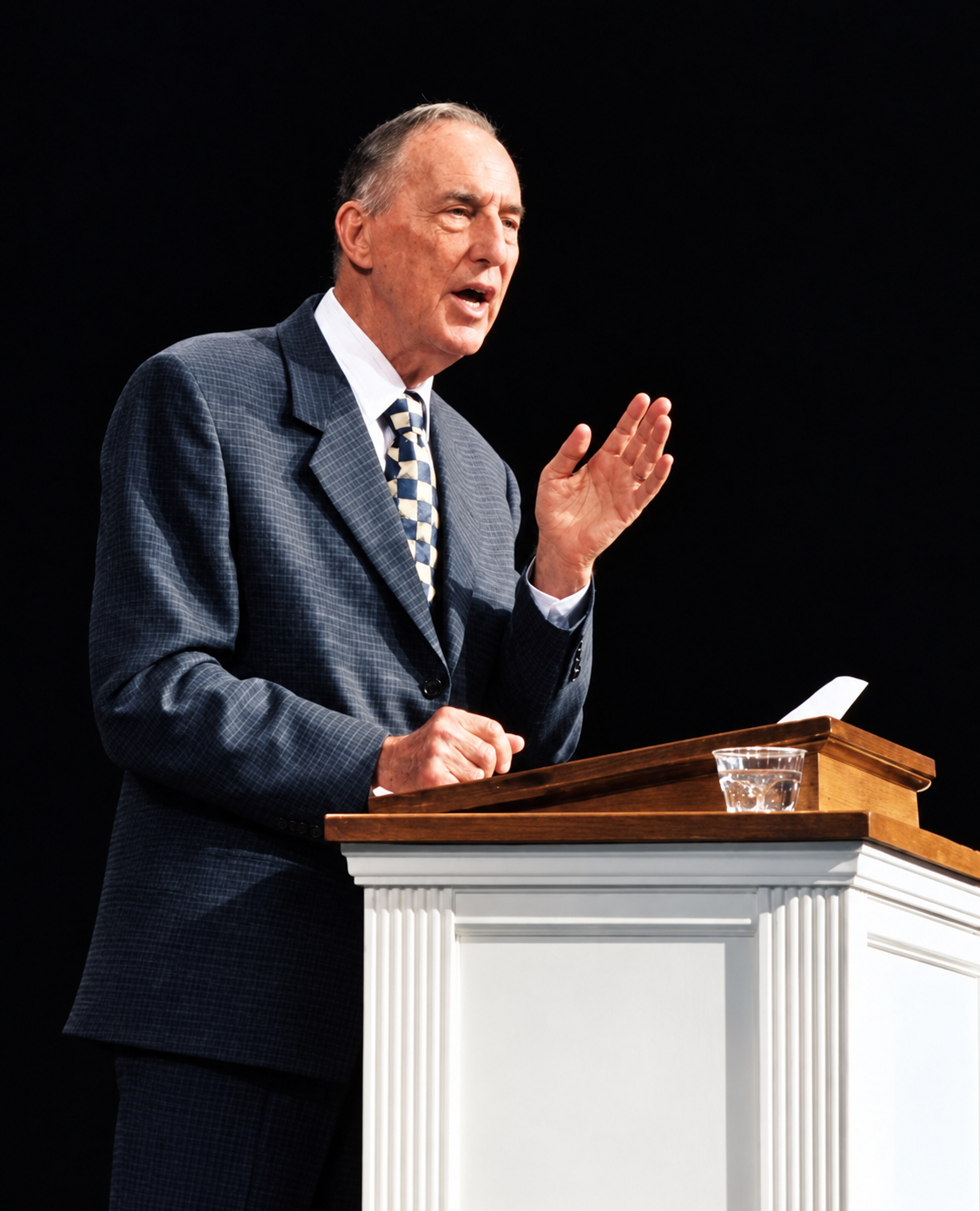 Derek Prince spreekt achter een preekstoel